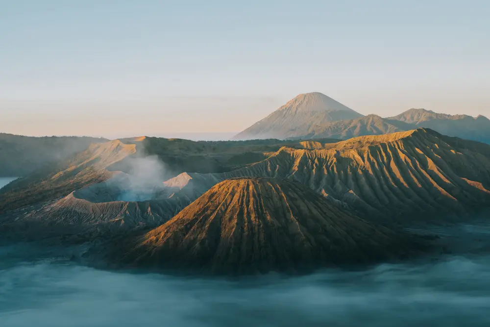 日出时分云雾环绕火山群 暖金色光照映层叠山体