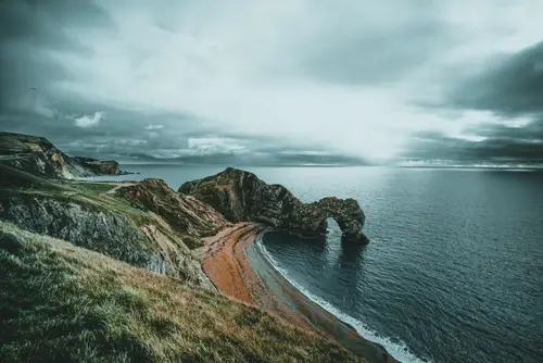 7952x5304 Desktop 自然风景 Wallpaper - 海滨天然石拱门海岸悬崖阴云密布的阴沉海景